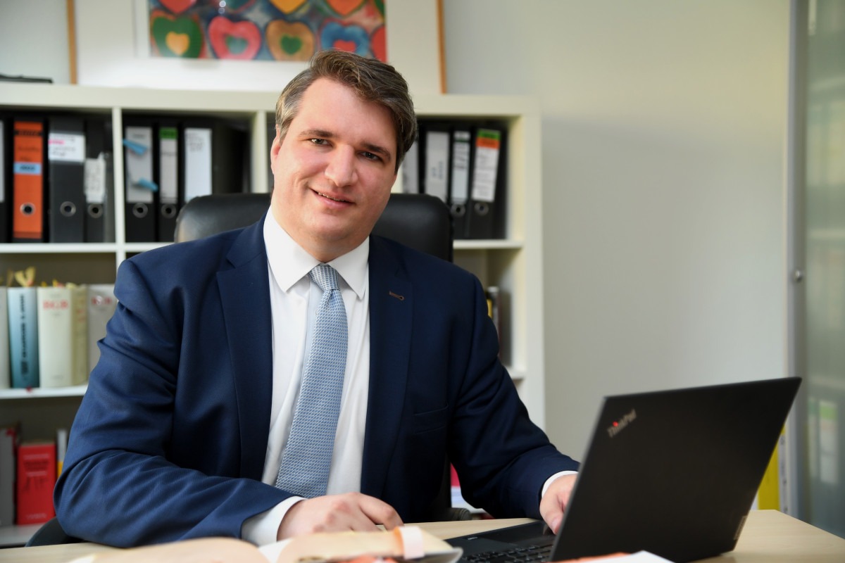 Bild von Rechtsanwalt Richard Schmidt am Schreibtisch mit aufgeklapptem Notebook bei der Arbeit